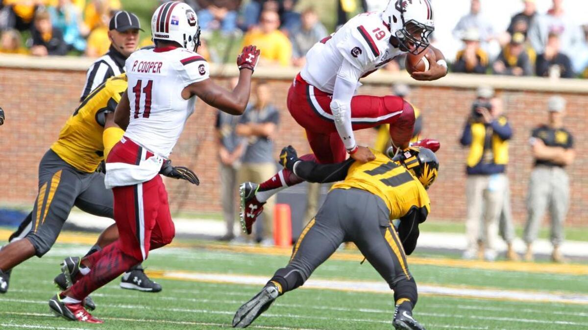 
South Carolina quarterback Lorenzo Nunez leaps over Missouri’s Aarion Penton during the first half Saturday in Columbia, Mo.
