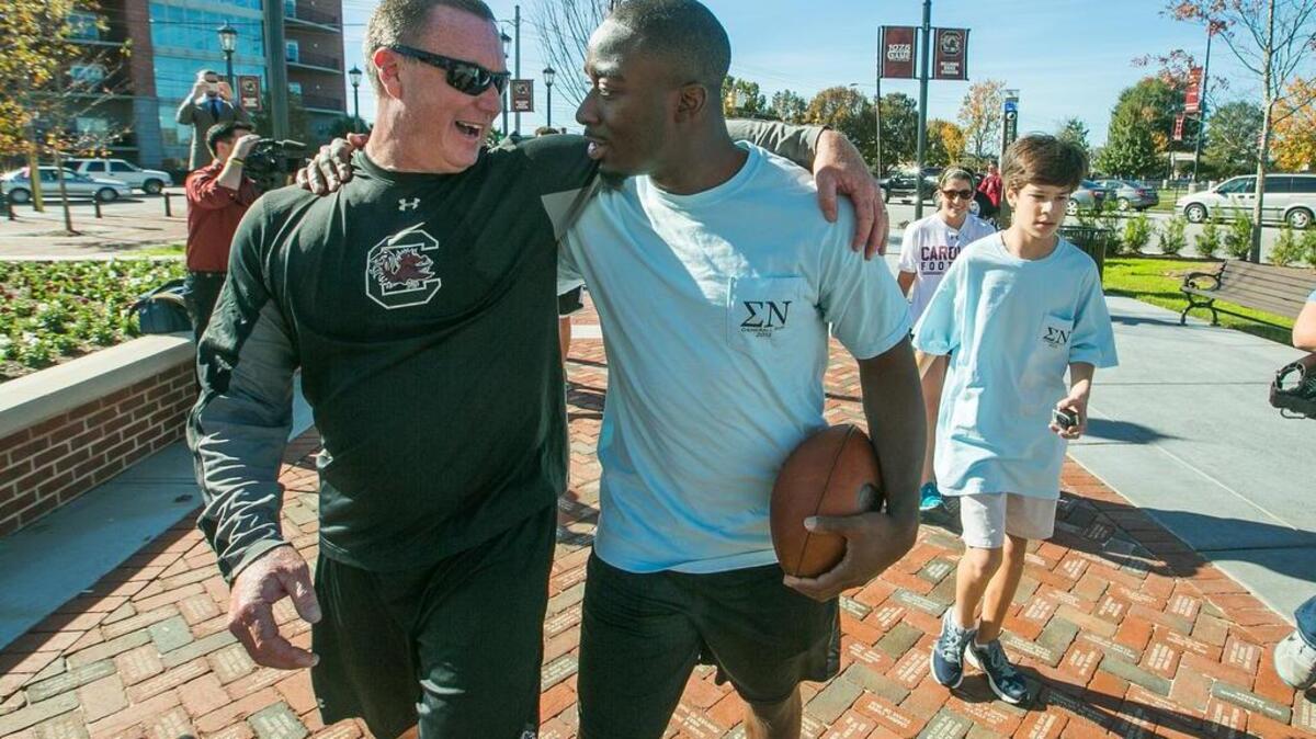 USC interim coach Shawn Elliott and Marcus Lattimore ran the final legs of the annual Sigma Nu Game Ball run before the USC-Clemson game.