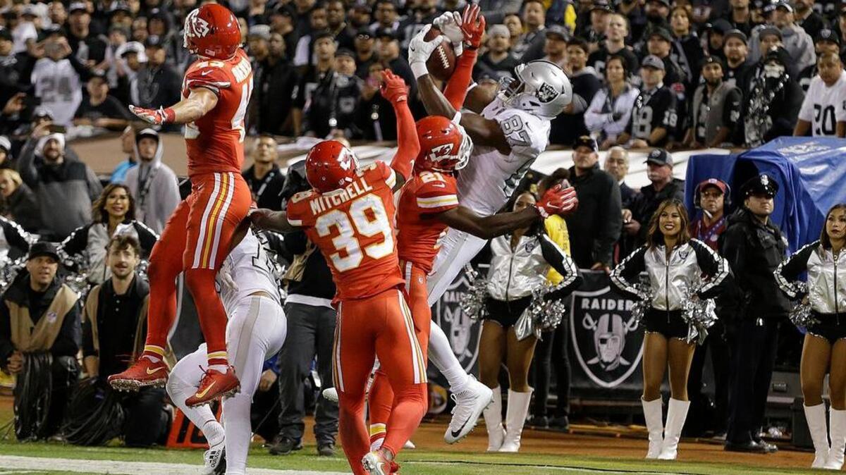 Oakland Raiders tight end Jared Cook (87) catches a pass against Kansas City Chiefs defenders during the second half of an NFL football game in Oakland, Calif., Thursday, Oct. 19, 2017.