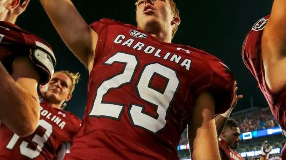 
South Carolina place kicker Elliott Fry (29) sings the alma maters after the game against the Tar Heels at Bank of America Stadium in Charlotte. 
