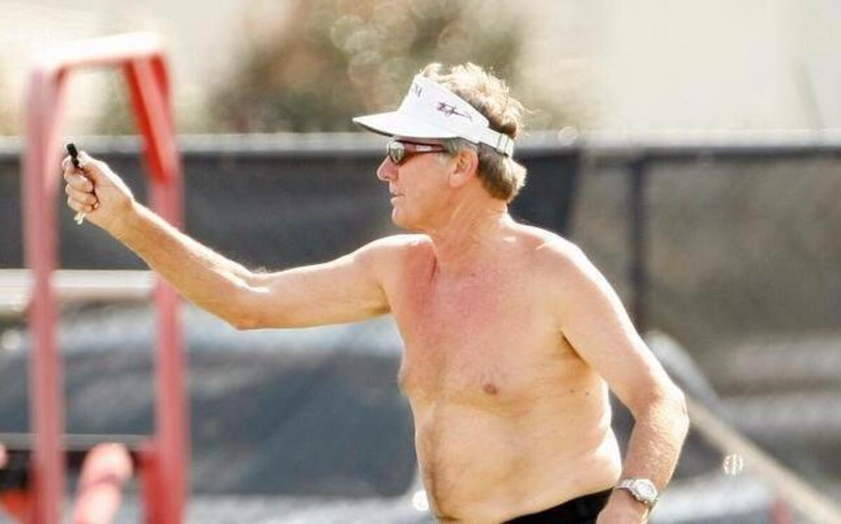 
File photo: USC head football coach Steve Spurrier goes shirtless and demonstrates throwing technique to quarterback Dylan Thompson.
