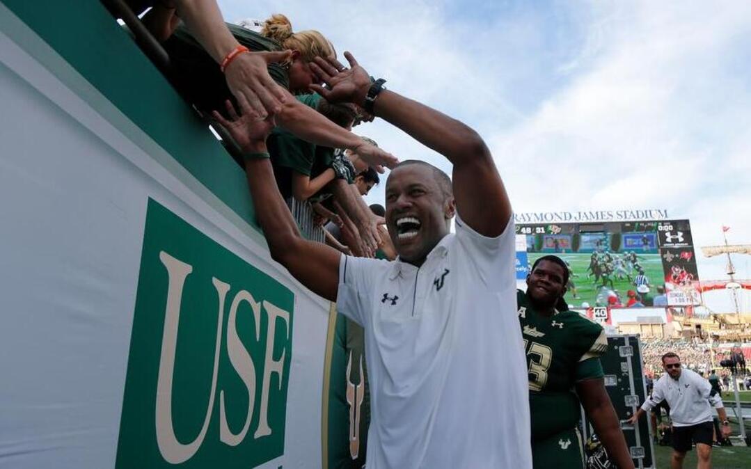 South Florida Bulls head coach Willie Taggart high fives fans after beating the UCF Knights at Raymond James Stadium.