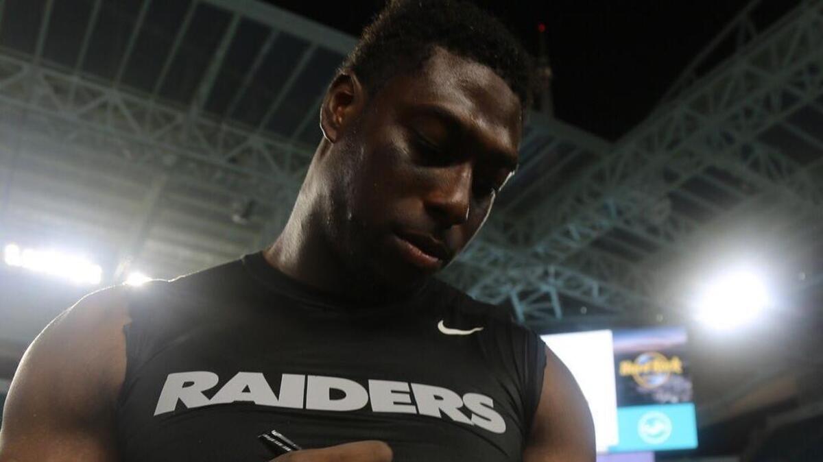 South Carolina Gamecock alum Jared Cook autographs the game ball he received for being named a player of the game on NBC’s Sunday Night Football.