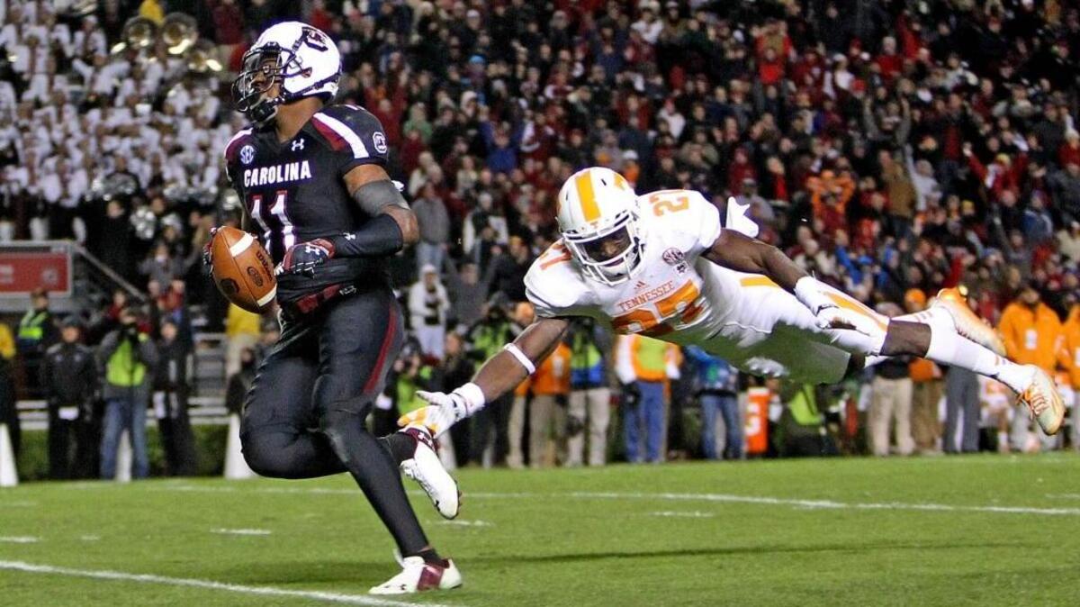 
South Carolina Gamecocks wide receiver Pharoh Cooper (11) avoids a diving tackle attempt by Tennessee Volunteers defensive back Justin Coleman (27) as he scores a touchdown on a long pass play at Williams-Brice Stadium, Saturday, November 1, 2014.
