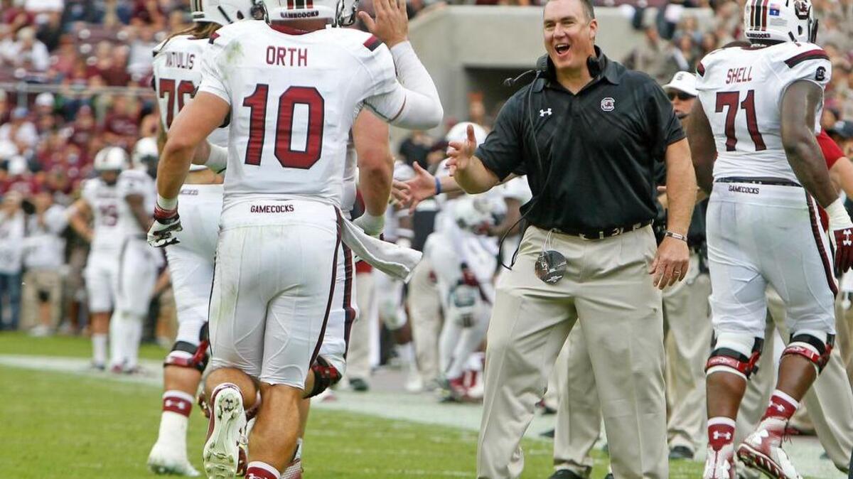 South Carolina quarterback Perry Orth (10) is congratulated by interim head coach Shawn Elliott after a Gamecock touchdown at Kyle Field in College Station, Texas, Saturday, October 31, 2015.
