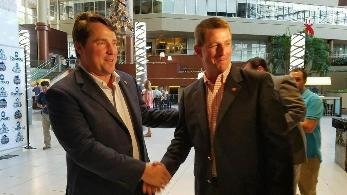 South Carolina football coach Will Muschamp shakes hands with Clemson coach and in-state rival Dabo Swinney at the Coaches for Charity event.
