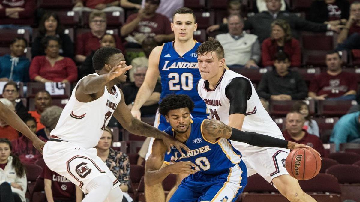 South Carolina’s Duane Notice (10) and Maik Kotsar (21) box in Lander's JR Washington (10) during their game Tuesday at Colonial Life Arena.