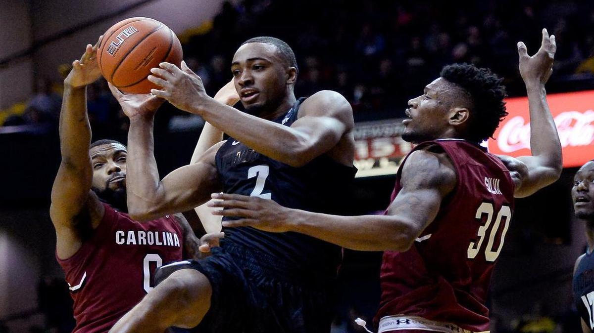 Vanderbilt’s Joe Toye passes the ball between South Carolina’s Sindarius Thornwell and center Chris Silva.