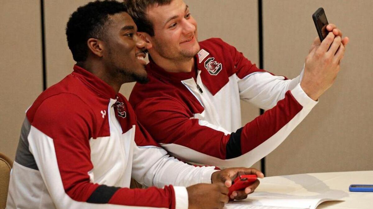South Carolina’s Duane Notice, left, and Mindaugas Kacinas take a selfie during the SEC men’s college basketball media day in Charlotte on Wednesday.