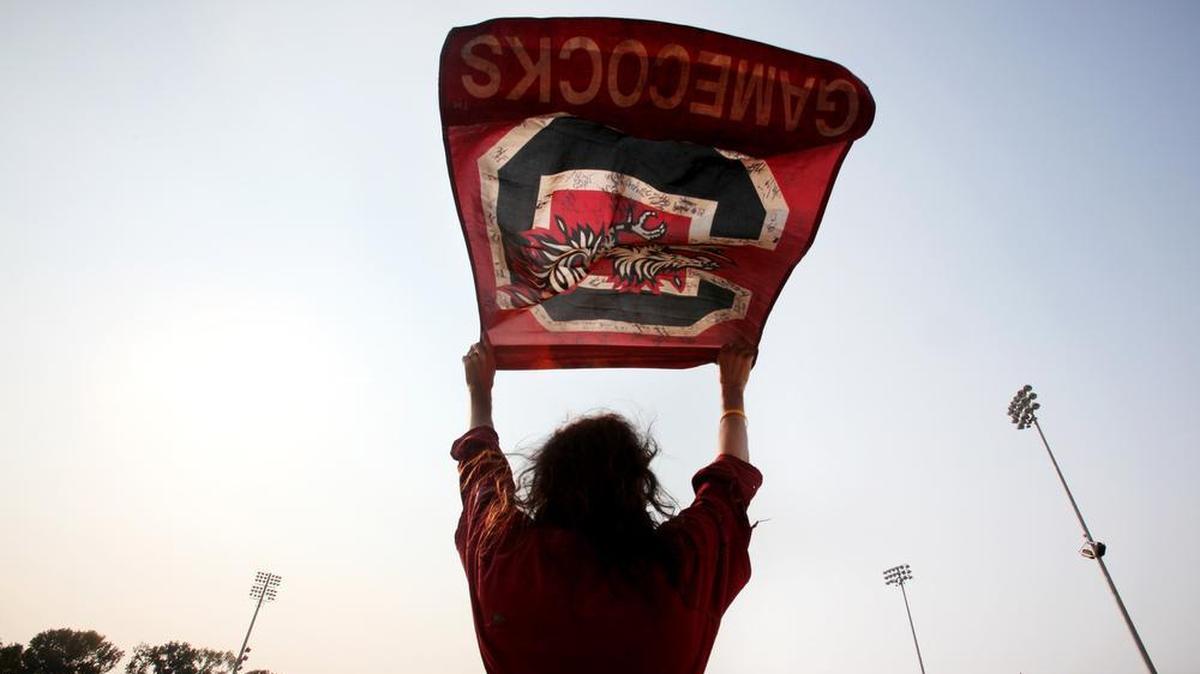 Carlton Thompson, aka “Gamecock Jesus,” waves a Gamecocks banner at Founders Park.
