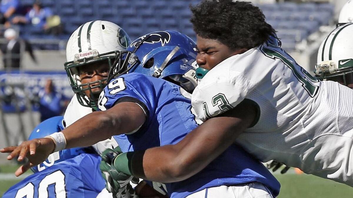 Miami Central defensive lineman and South Carolina commit Keir Thomas tackles with out his helmet in a state title game.