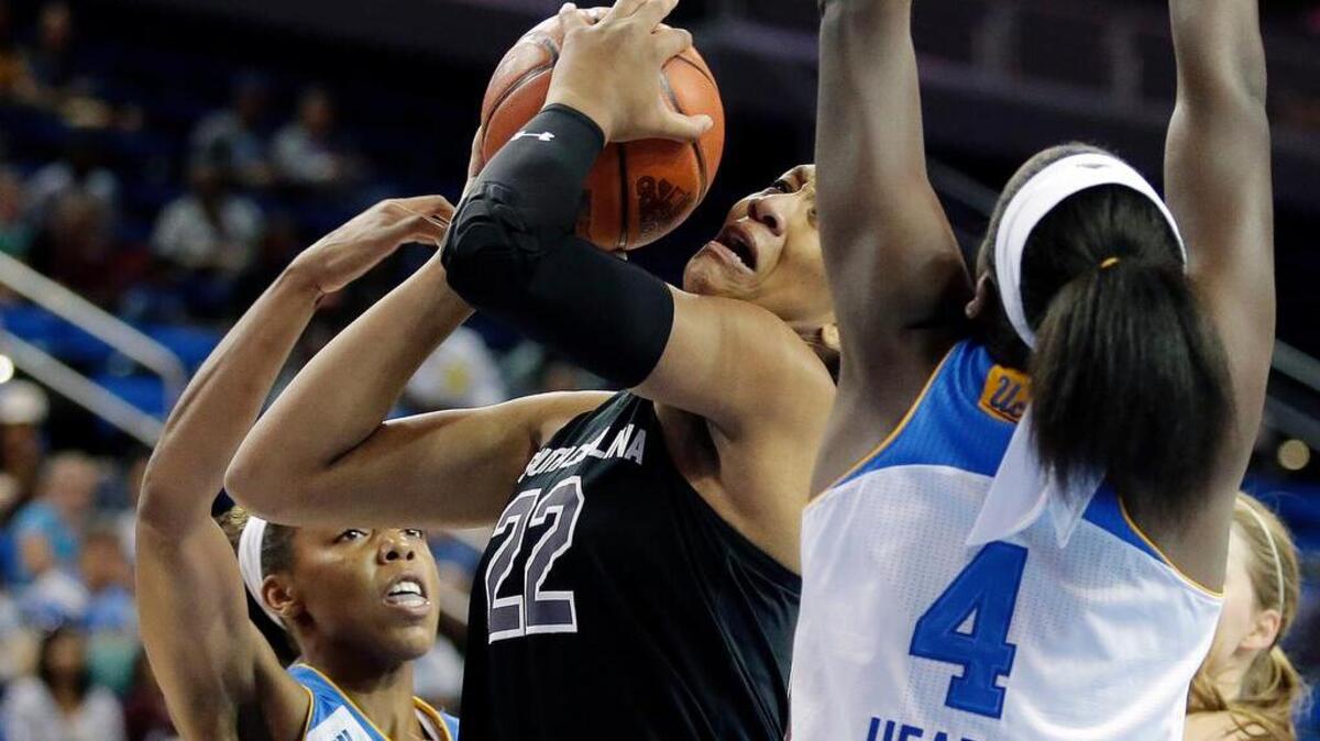 South Carolina forward A'ja Wilson, middle, drives to the basket between UCLA forward Ashley Hearn, right, and guard Nirra Fields.