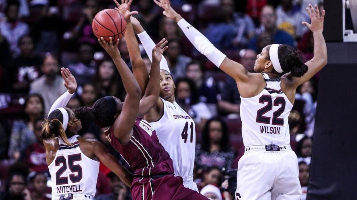 Elon's Shay Burnett (5) is pressured by South Carolina's Tiffany Mitchell (25) Alaina Coates (41) and A'ja Wilson (22) during the first half of action in the Colonial Life Arena.
