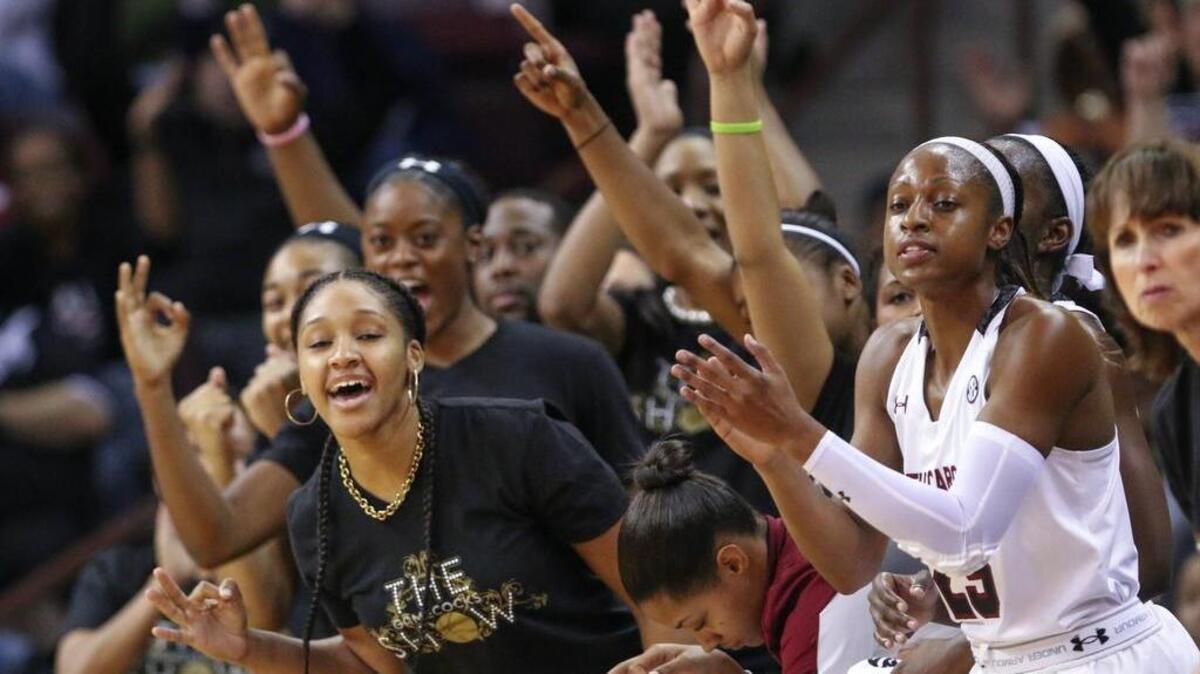 Alaina Coates, Tiffany Davis and Tiffany Mitchell lead teammates in celebrating a 3-point shot by Tina Roy during the first half of action in the Colonial Life Arena.