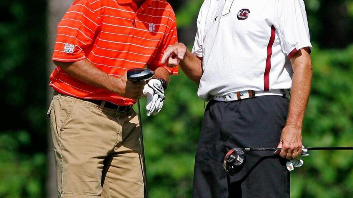 Clemson head football coach Dabo Swinney jokes with then-USC head football coach Steve Spurrier at the 2011 Chick-fil-A Challenge Charity Golf Tournament.