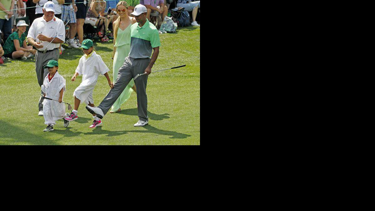 
Tiger Woods has some fun with his children Sam and Charlie as he walks up No. 2 during the Par 3 Contest of the Masters at Augusta National Golf Club, Wednesday, April 8, 2015. 
