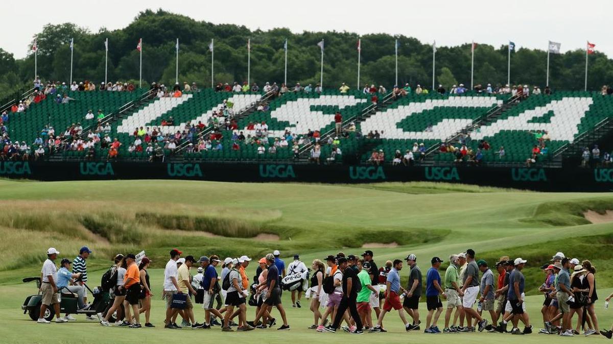 Fans walk near the 18th hole of the U.S. Open golf tournament Friday, June 16, 2017, at Erin Hills in Erin, Wis.