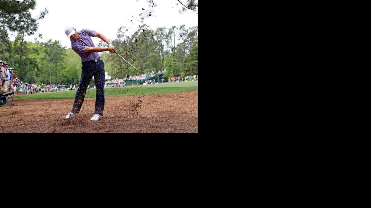 
Jordan Spieth hits his approach shot out of the pine straw on No. 14 during Friday's round of the 2015 Masters. The 21-year-old Texan, was at 14 under for the tournament. 
