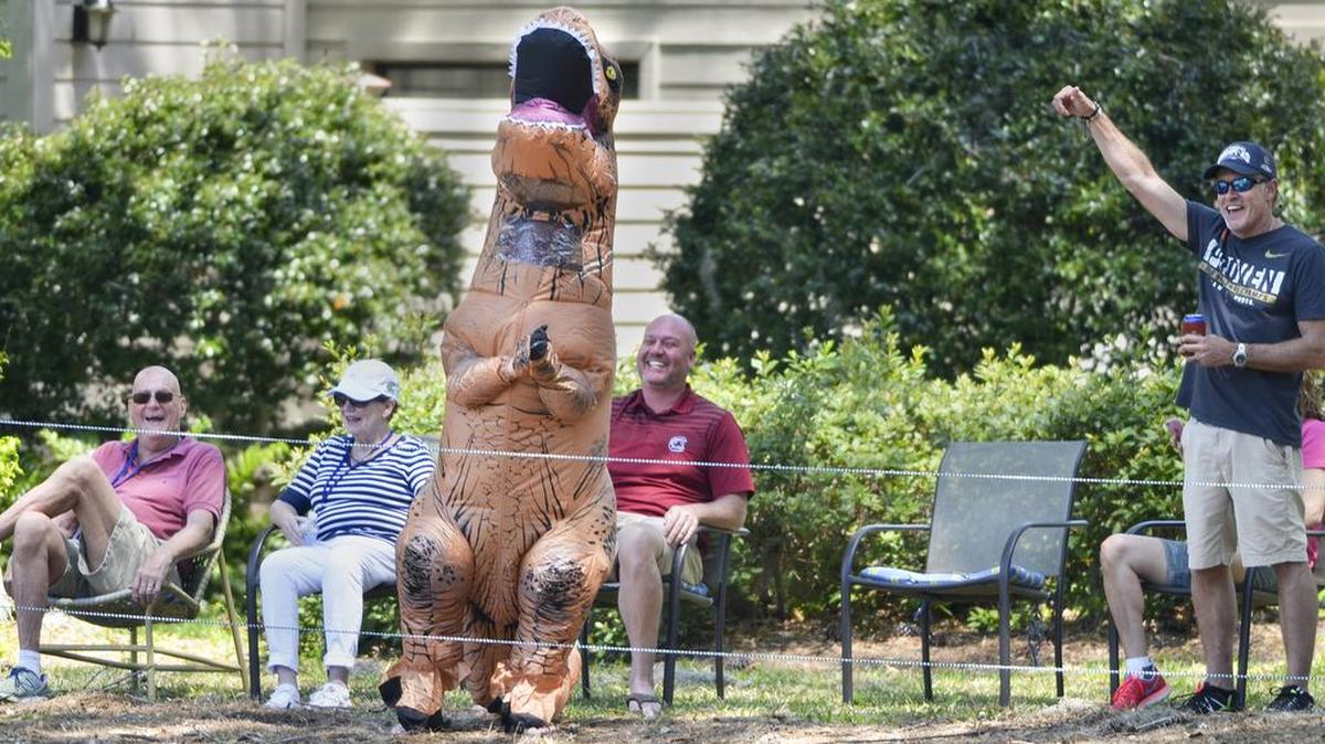 A fan in a dinosaur suit applauds Luke Donald, Graeme McDowell and Ernie Els as their group makes its way down the first fairway during the second round of the RBC Heritage Presented by Boeing on Friday, April 14, 2017 at Harbour Town Golf Links on Hilton Head Island.