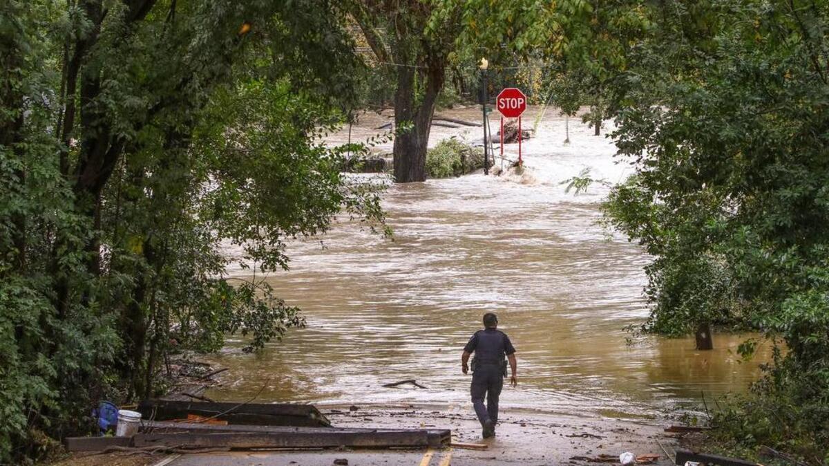 A Lexington city police officer walked to the edge of Twelve Mile Creek to check on the floodwaters that broke the Old Mill Dam in Lexington. 10/4/15