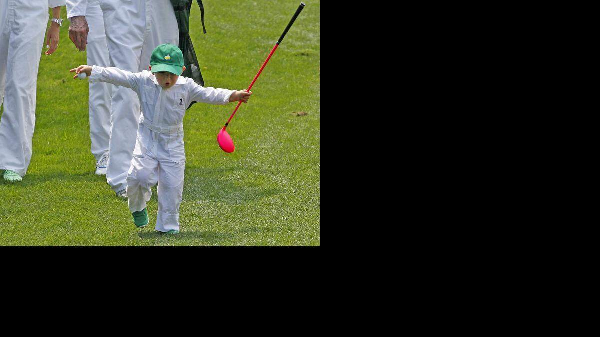
Bubba Watson’s son Caleb runs down the hill on No. 1 with his replica pink Ping driver during the Par 3 Contest on Wednesday.
