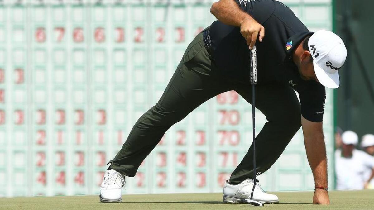 Roberto Diaz picks his ball out of the cup after his putt on the 18th green during the second round of the 2017 U.S. Open golf tournament at Erin Hills.