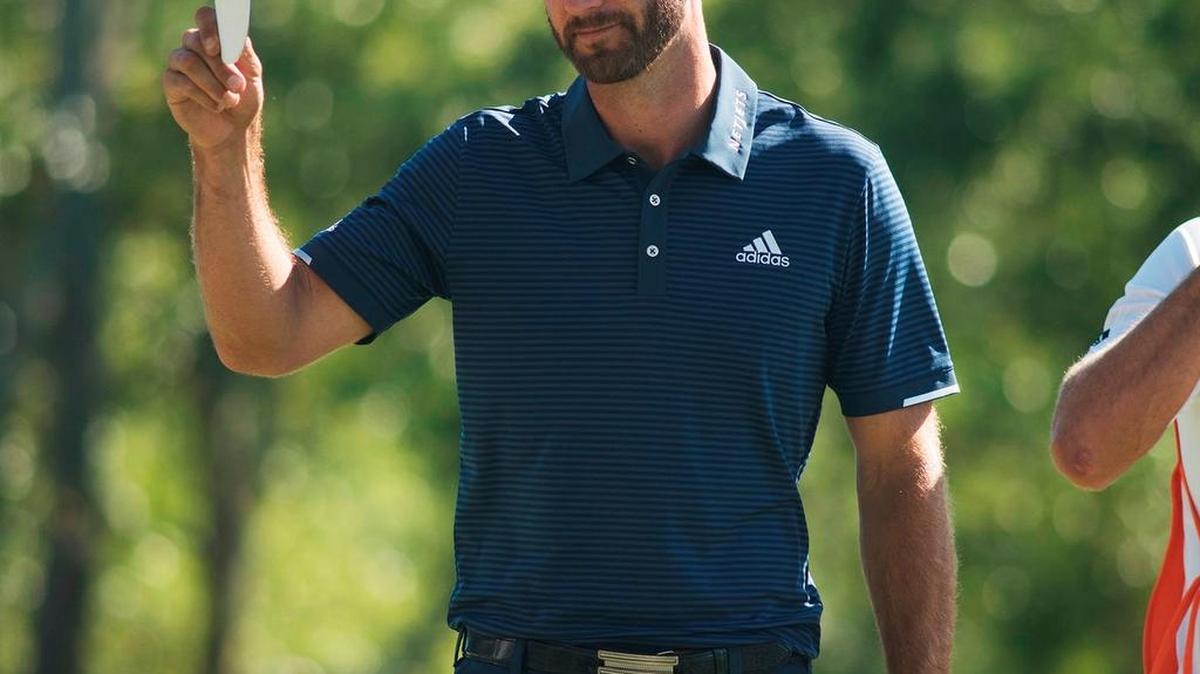 Dustin Johnson tips his hat to the fans on the 18th hole during the final round of the Wells Fargo Championship golf tournament at Eagle Point Golf Club in Wilmington, N.C.