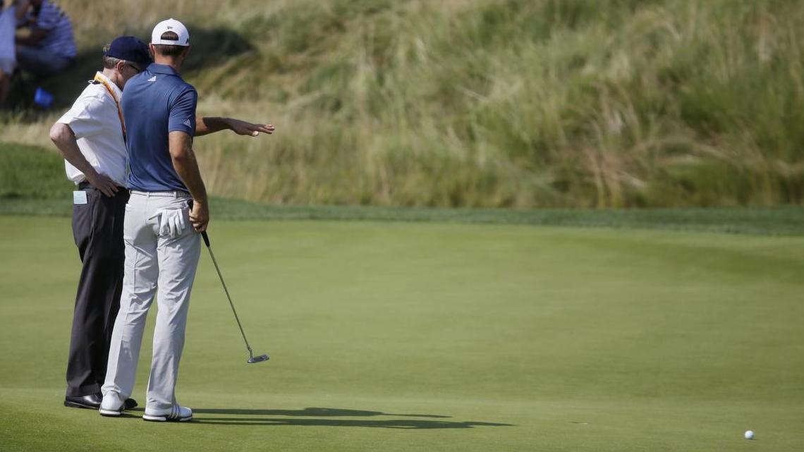 Dustin Johnson (right) talks to a rules official on the fifth green during the final round of the U.S. Open.