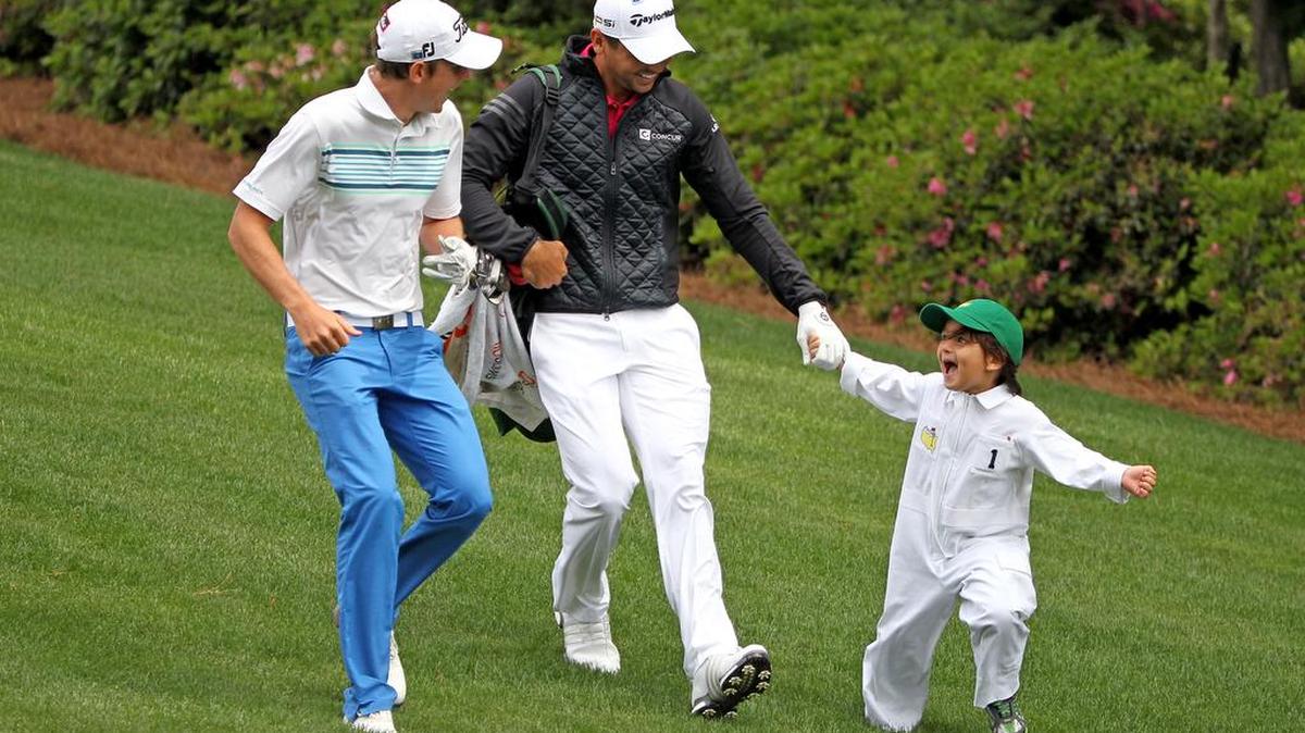 Cameron Smith, left, watches as Jason Day, middle, is pulled by his son Dash as they head to the 3rd hole Wednesday during the Masters Par-3 Contest at Augusta National Golf Club in Augusta, Ga.