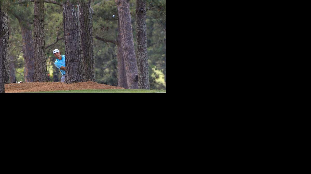 
Dustin Johnson hits from the trees Thursday on the 17th hole during the first round of the Masters in Augusta. 
