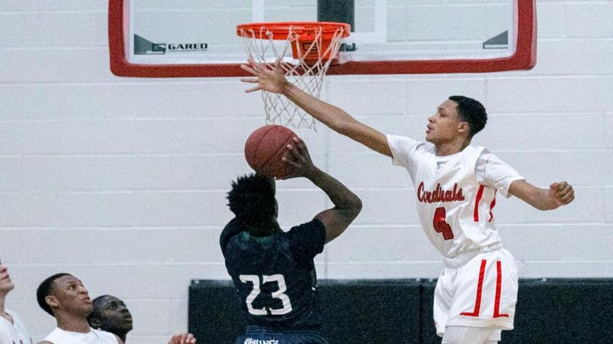 Cardinal Newman’s Christiaan Jones blocks the shot of Heathwood Hall’s Justice Hill during the Cardinals’ victory Friday.