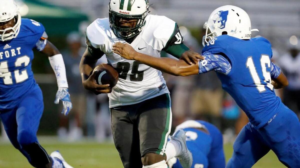 Dutch Fork’s Bryson Cannon runs as Fort Dorchester’s Jaquan Gomillion goes for the tackle Thursday.