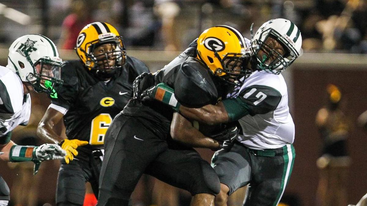 Dutch Fork’s Alex Smith (17) wraps up Greenwood’s Malik Cater during their Battle on the Bluff game Friday night.