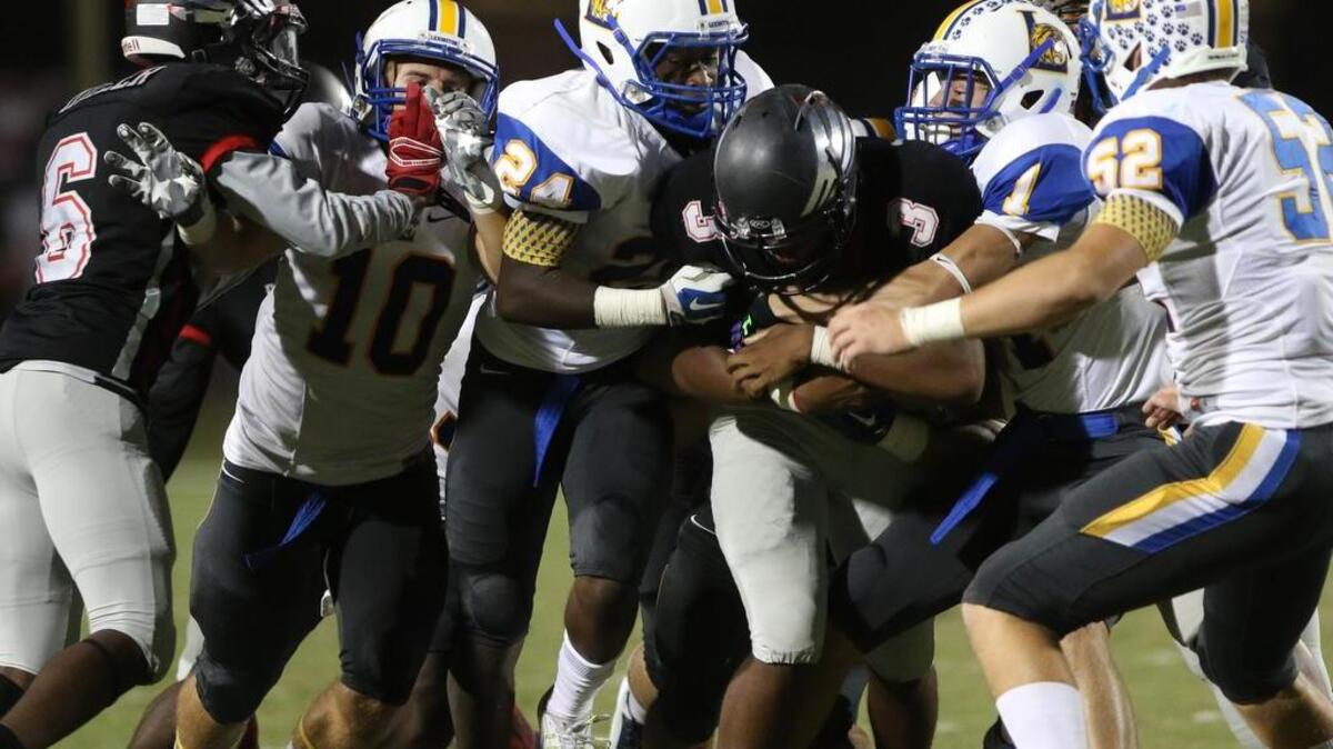 
Lexington’s Michael Broadwater (24) and Nick Graves (1) wrap up Westwood quarterback Jalen Smith during Friday night’s game.
