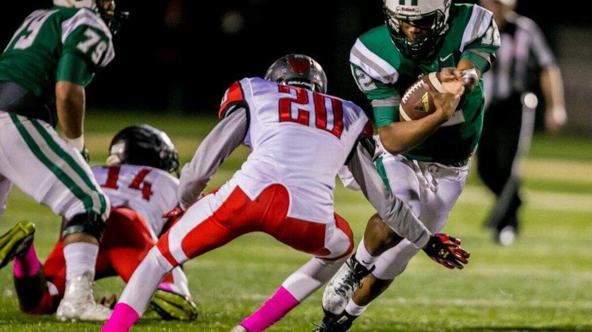 Dutch Fork quarterback Cole Douglas rushes past Westwood's Shane Harkness during the game between Westwood High School at Dutch Fork High School. (photo by Jeff Blake)