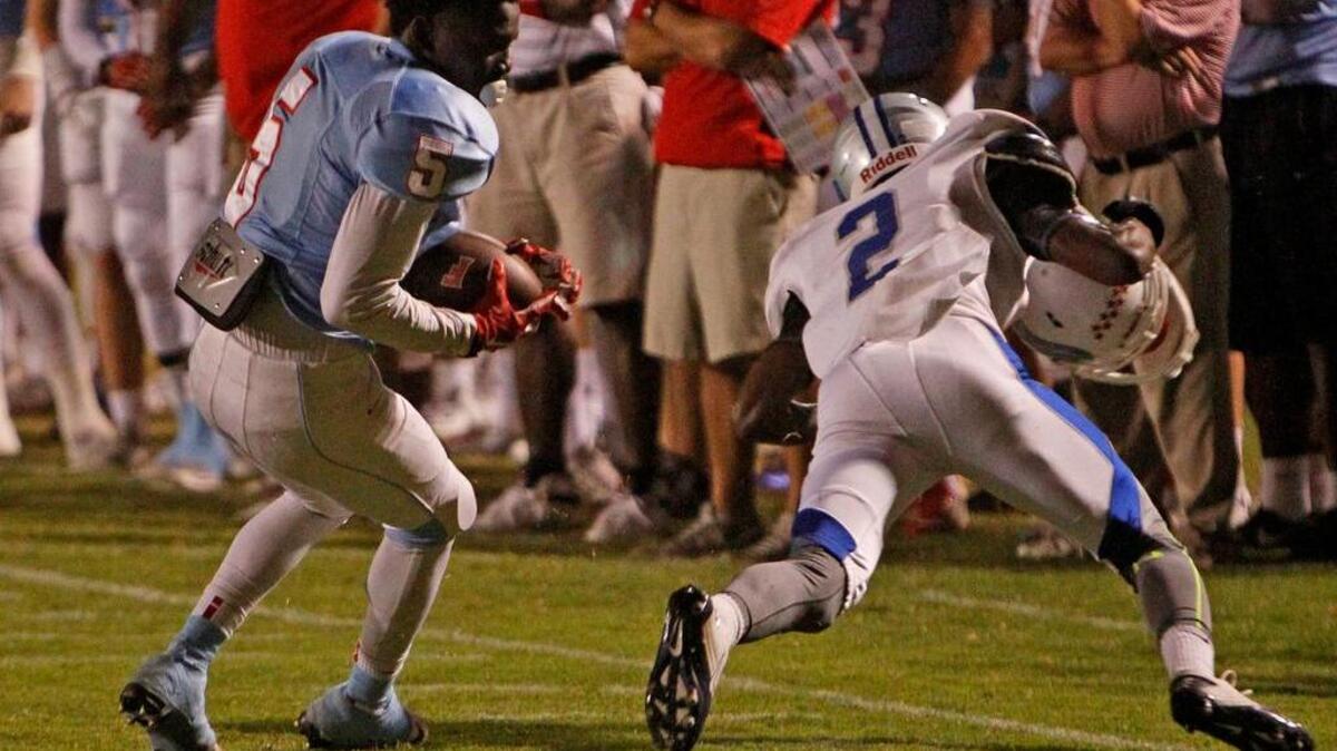 
A.C. Flora's Cam Riley leaves his helmet and Airport High's Keryon Richardson behind after a catch in the first half.
