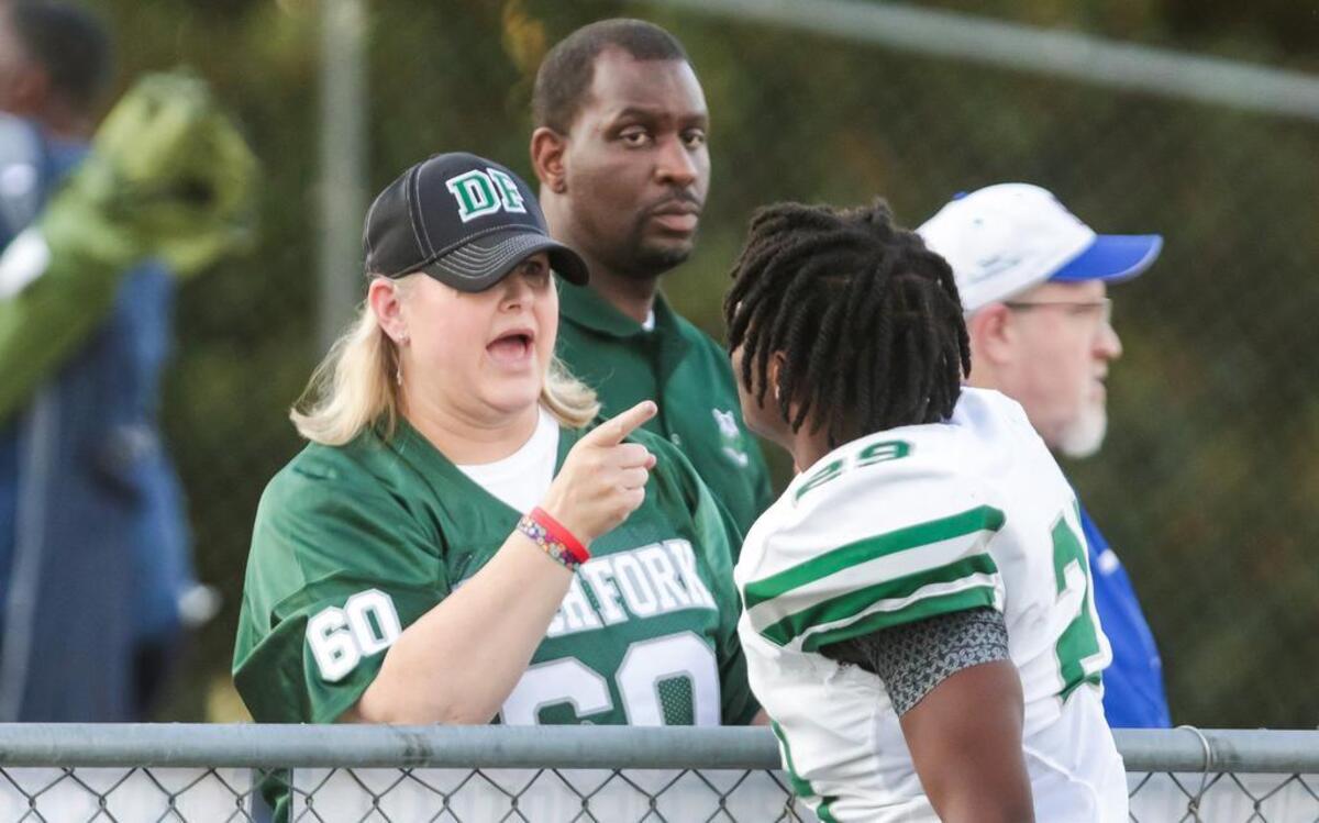 Kelly Hewins Alkhatib, the mother of Dutch Fork tackle Jack Alkhatib (60), speaks with linebacker Chandler Perry (29) before the game at Byrnes.