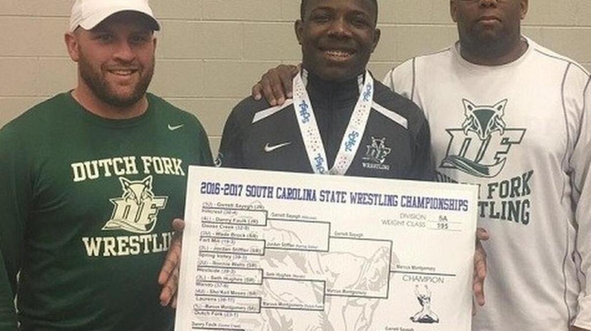 Dutch Fork wrestling coach Kyle Kimrey, left, poses with Marcus Montgomery after winning a state title. Kimrey will be leaving Dutch Fork to take over White Knoll wrestling program.