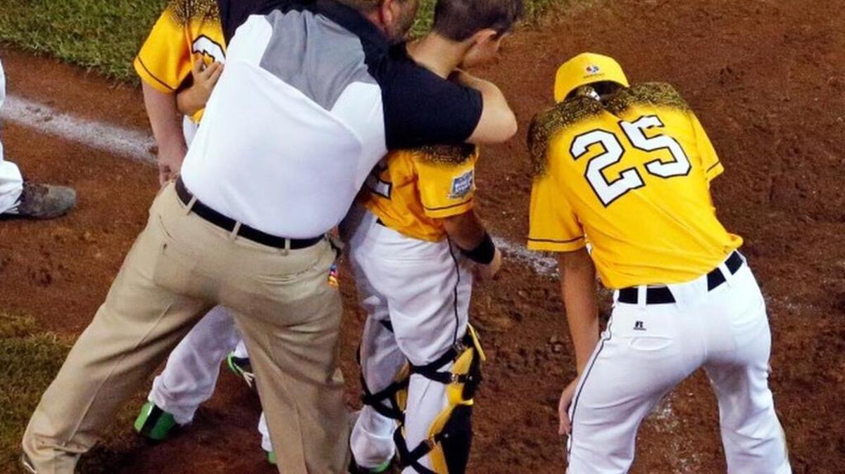 
Taylors, South Carolina coach Rick Grimes consoles his players after Lewisberry, Pennsylvania's Jaden Henline hit a walk-off, two-run double, off Taylors, South Carolina's Ryan Soug during the sixth inning of a baseball game in United States pool play at the Little League World Series tournament in South Williamsport, Pa., Sunday, Aug. 23, 2015. Lewisberry, Pennsylvania won 9-8. (AP Photo/Gene J. Puskar) 
