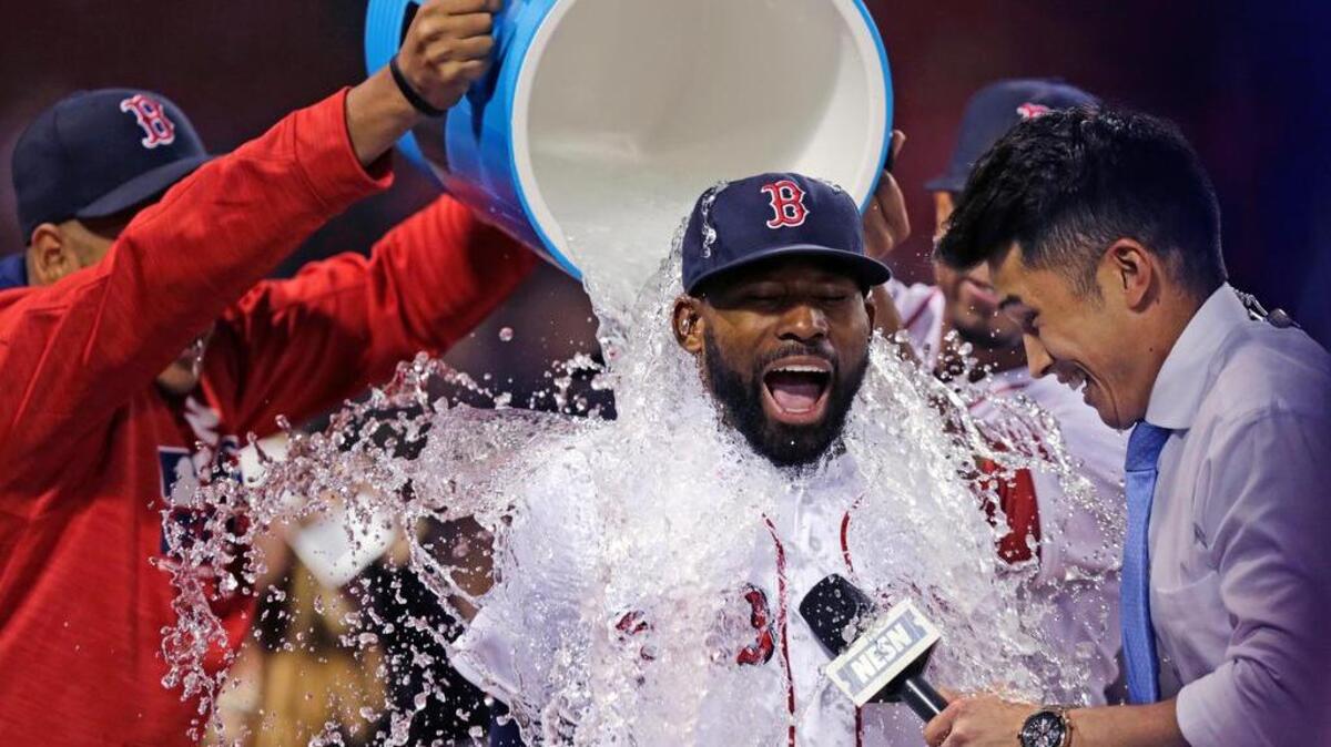 Boston Red Sox's Jackie Bradley Jr. is doused with a bucket of ice water by teammates after a 13-3 win against the Oakland Athletics at Fenway Park in Boston, Wednesday, May 11, 2016. Bradley had two home runs and six RBIs in the game. At right is baseball sideline reporter Gary Striewski.