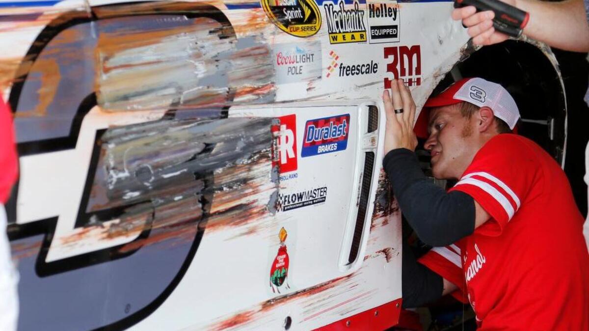 
A crew member works on Austin Dillon's car after he scraped the wall during a NASCAR Sprint Cup practice session at Darlington Raceway.

