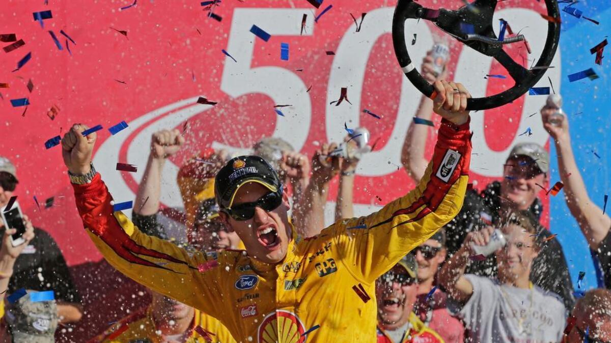 
Joey Logano celebrates in Victory Lane after winning the NASCAR Sprint Cup series race at Charlotte Motor Speedway on Sunday. The win guarantees a spot for Logano in the third round of the Chase of the Championship. 
