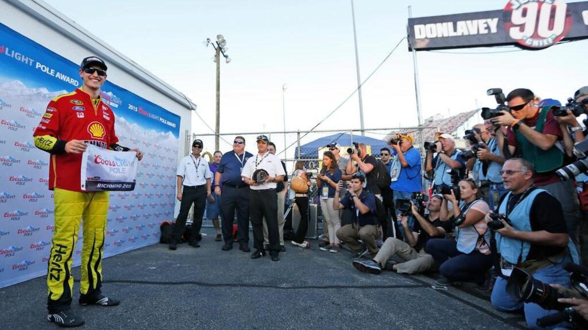 
Joey Logano holds the pole position flag as he faces the media after qualifying for Saturday's NASCAR Sprint Cup auto race at Richmond International Raceway in Richmond, Va., Friday, Sept. 11, 2015. (AP Photo/Chet Strange)
