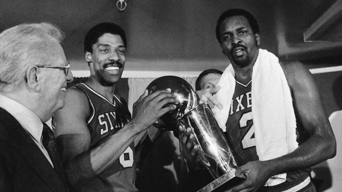 
 Philadelphia 76ers Moses Malone, right, and Julius Erving hold the 1983 NBA Championship trophy after defeating the Los Angeles Lakers in Los Angeles in this 1983 photo. Malone, a three-time NBA MVP and one of basketball’s most ferocious rebounders, died Sunday, according to a The Philadelphia 76ers statement. He was 60. 
