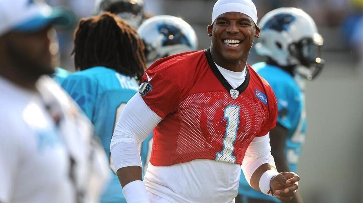 Carolina Panthers quarterback Cam Newton smiles as he and his teammates run to center field at Gibbs Stadium on the campus of Wofford College in Spartanburg, SC on Friday, July 31, 2015.