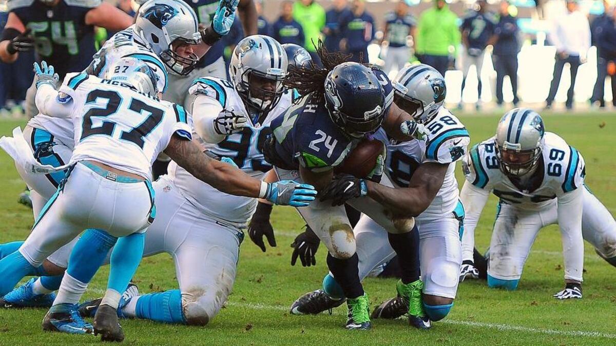 The Carolina defense makes the tackle on Seattle running back Marshawn Lynch.