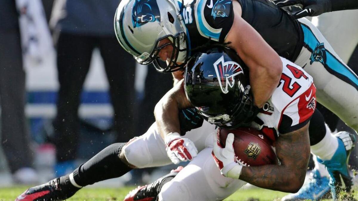 Atlanta Falcons' Devonta Freeman (24) is tackled by Carolina Panthers' Luke Kuechly (59) in the first half of an NFL football game in Charlotte, N.C.