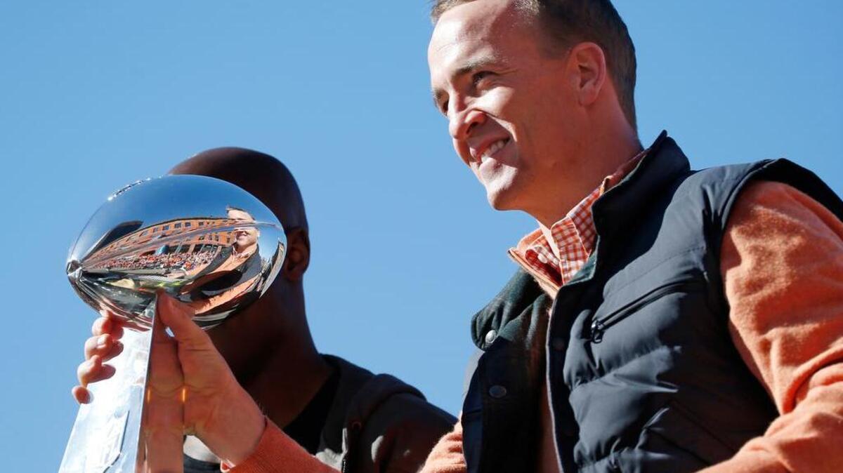 Denver Broncos quarterback Peyton Manning holds the Lombardi Trophy during a parade for the NFL football Super Bowl champions, Tuesday, Feb. 9, 2016, in Denver.