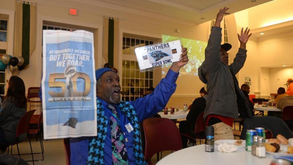 Dirk Dirk Young and Thomas Threatt cheer as homeless participants enjoy a tailgate party and chili cookoff and watch the Panthers-Broncos Super Bowl game Sunday at St. John’s Episcopal Church on Carmel Road. Brown has been out of prison since last year.