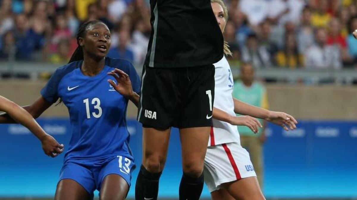 U.S. goalkeeper Hope Solo, center, grabs the ball as France’ss Kadidiatou Diani looks on.